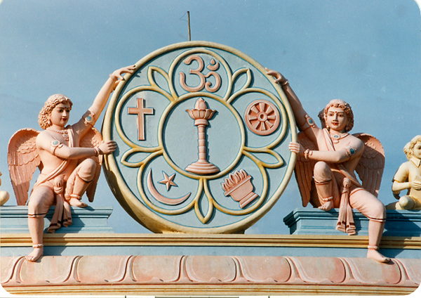 Figurines over main compound temple gate with sarva dharma symbol